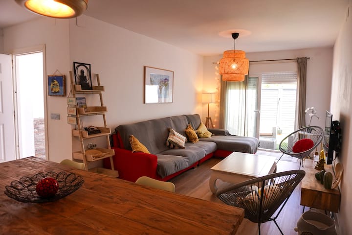 Step into our cozy living room with a large sofa and smart TV, including Netflix and all channels. The spacious dining table is perfect for meals, and patio access invites you to enjoy outdoor dining and relaxation.