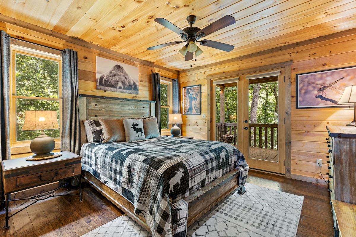 חדר שינה ראשי קווין עם דלתות זכוכית כפולות המובילות לאזור הדק וטלוויזיה חכמה Roku 43 אינץ'. 