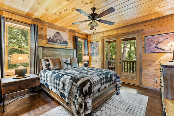 主层标准双人床卧室，配有通往露台区域的双层玻璃门和43英寸Roku智能电视。 