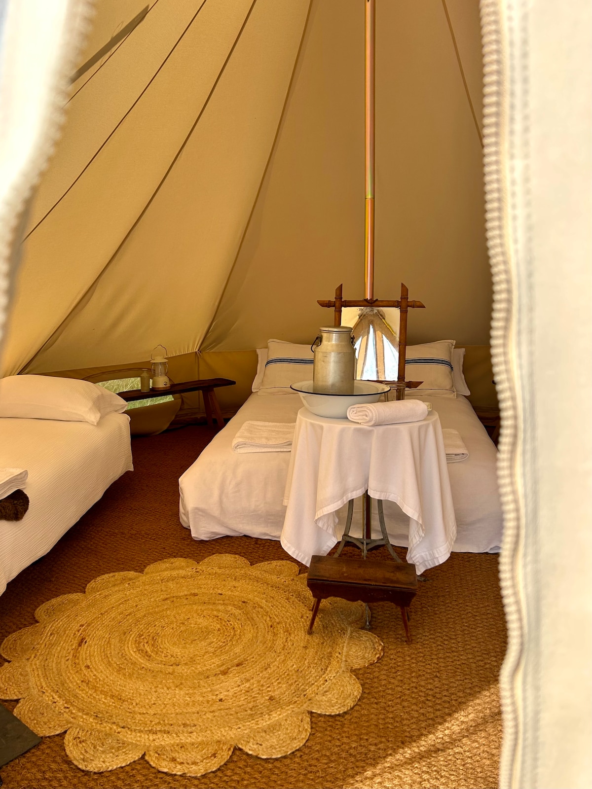 Luxury 5m canvas bell tent with a double bed and an optional single, fold out bed. 
All beds are made up with fresh linen and lambswool blankets.
Wood burning stove.
Wash stand.
Rechargeable lanterns.
Towels.