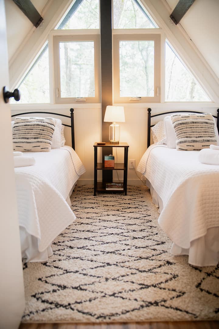 Upstairs Bedroom with two twin beds - Cozy Twin Bedroom – This bright and inviting upstairs bedroom features two comfortable twin beds with soft linens, charming décor, and plenty of natural light streaming in from the windows.