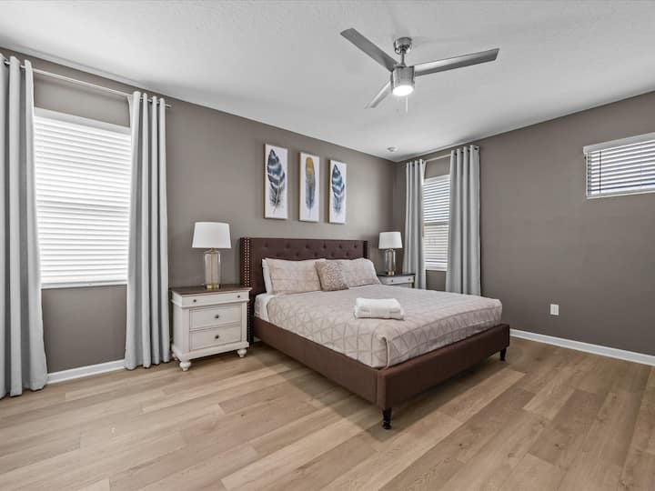 Lyxig huvudsvit med en king size-säng och eget badrum. Koppla av med stil med chic inredning och direkt tillgång till poolområdet. lyxigt-familjvänligt nöje i denna semester herrgård nära Disney