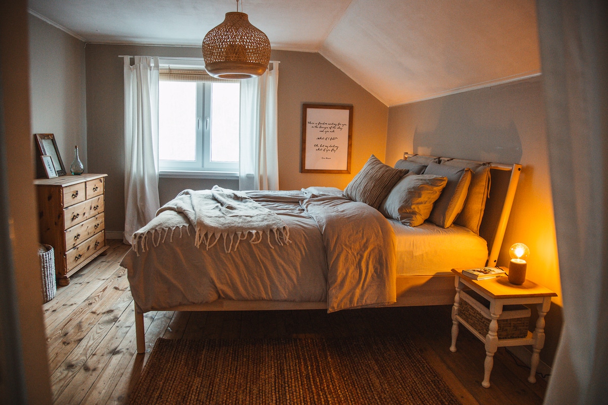 Das Hauptschlafzimmer verfügt über ein Queensize-Doppelbett (160 x 200) und ein Fenster mit Blick auf den üppig grünen Wald.