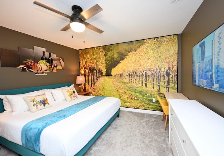 BR 4 France King: Step into the stunning French vineyard in autumn and  celebrate the harvest with luscious grapes, cheese,  and wine.   Bed with award-winning firm mattress, water view, ceiling fan, smart TV, desk/chair, accent lounge chairs. 
