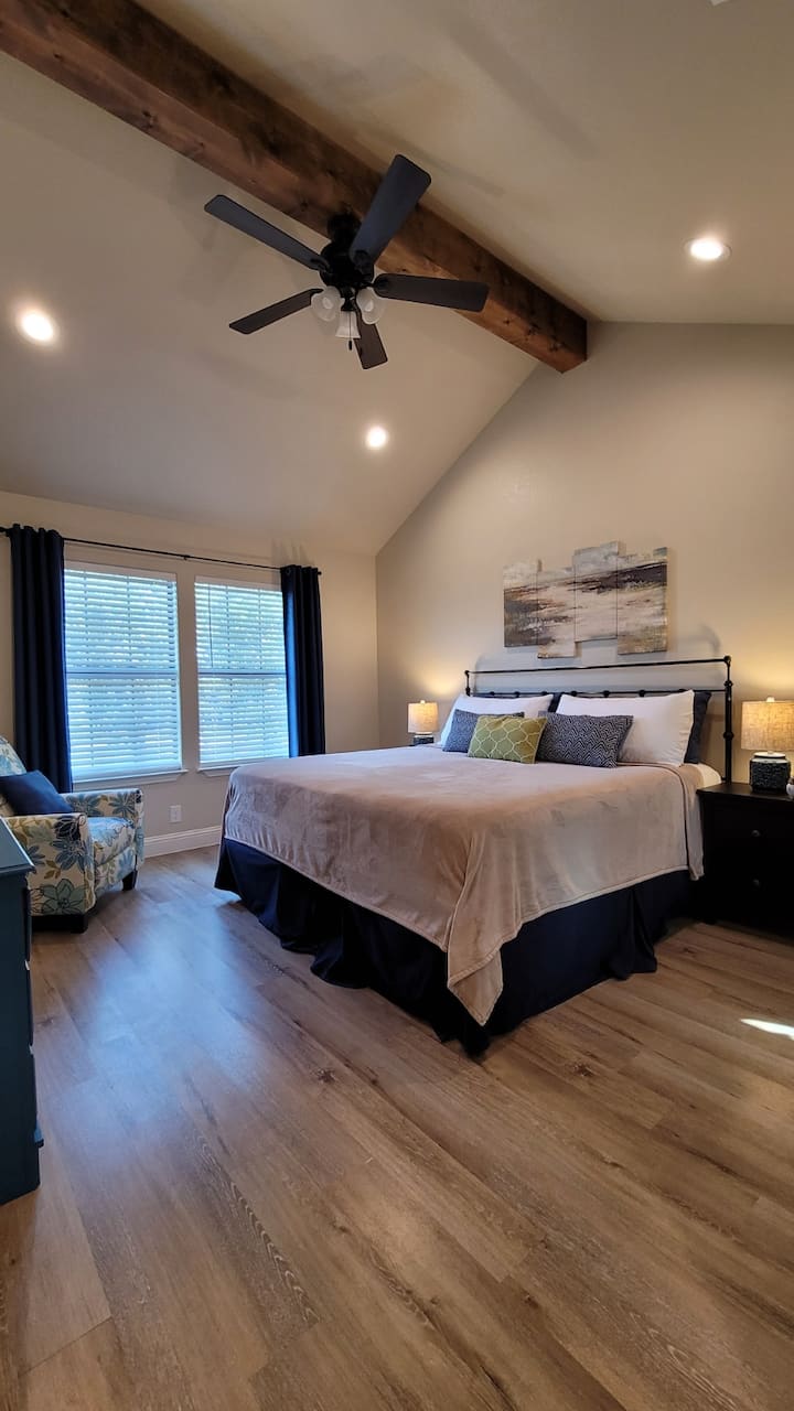 غرفة نوم رئيسية جميلة مع أسقف مقببة وكرسي متحرك وسرير بحجم كبير.