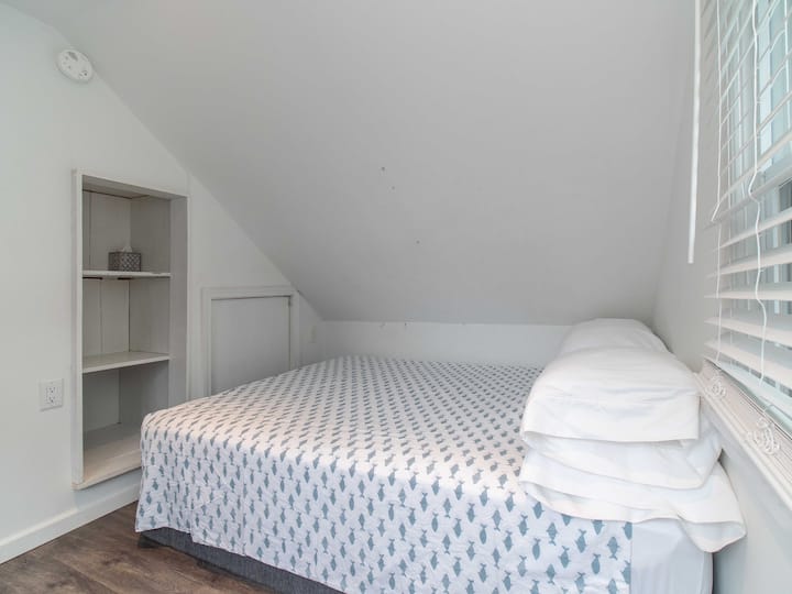Queensize bed met raam met uitzicht op het meer (niet afgebeeld) in de loft