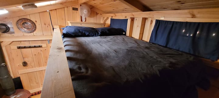 The sleeping loft measures 12 feet long by 5 feet wide and has a low ceiling of about 3 feet.