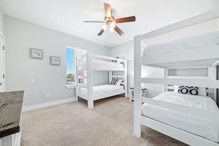 Оваа весела соба на спрат нуди два комплета цврсти бели кревети на спрат со кадифена постелнина, нагласени со разигран крајбрежен декор. Големата природна светлина и меките теписи создаваат пријатна, пријатна атмосфера, совршена за деца, тинејџери или групи за опуштање и полнење!