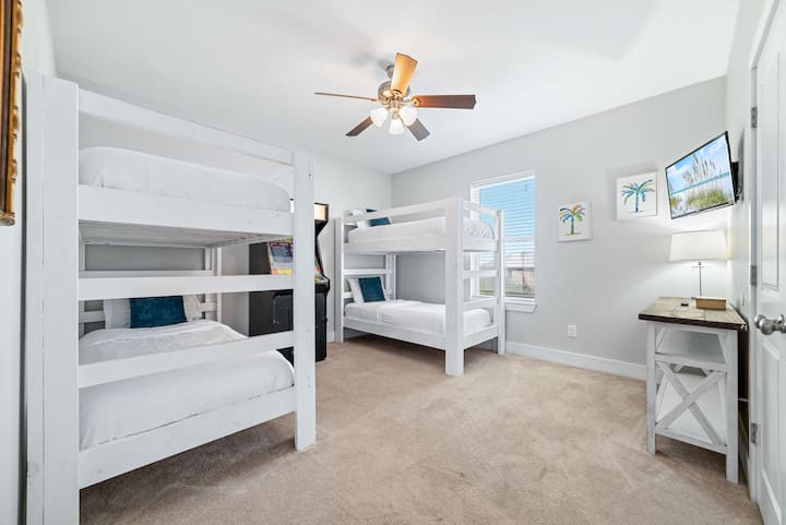 Во оваа динамична соба на спрат ве очекува забава со два цврсти бели кревета на спрат, кадифена постелнина и разиграна уметност на палми. Телевизорот со рамен екран и ретро аркадната игра додаваат возбуда, што го прави најдоброто место за дружење за деца и тинејџери по денот на плажа!