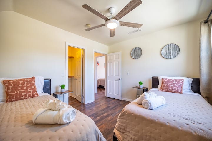 Charming Bedroom: Bright space with two comfy beds and a modern ceiling fan for ultimate relaxation!