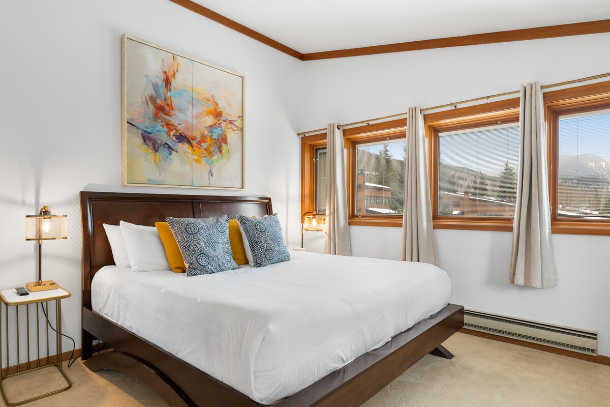 Chumba cha kulala cha msingi cha ghorofa kilicho na televisheni, sehemu ya kukaa na bafu la chumba cha kulala. 