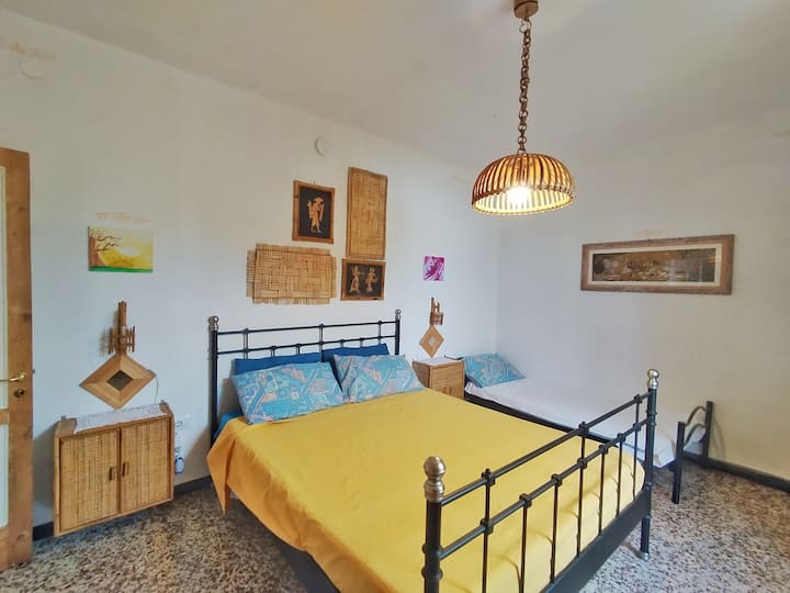 La habitación con cama matrimonial y 2 individuales.