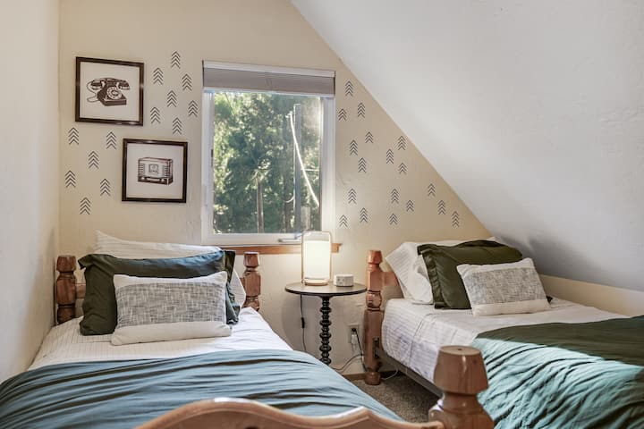 Спалня на горния етаж, подходяща за деца, с две единични легла и просторна гардеробна за играчки и принадлежности.