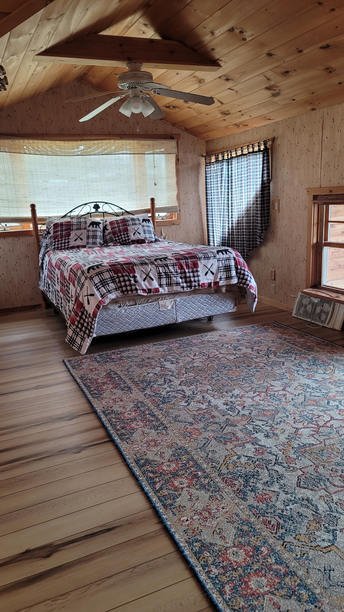 ห้องนอนสไตล์ลอฟท์พร้อมระเบียง มีเตียงควีนไซส์