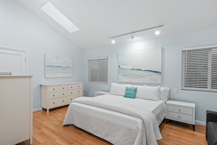 Chumba kikubwa cha kulala chenye kitanda cha kifalme, bafu, sofa na kabati kubwa la kutembea.  