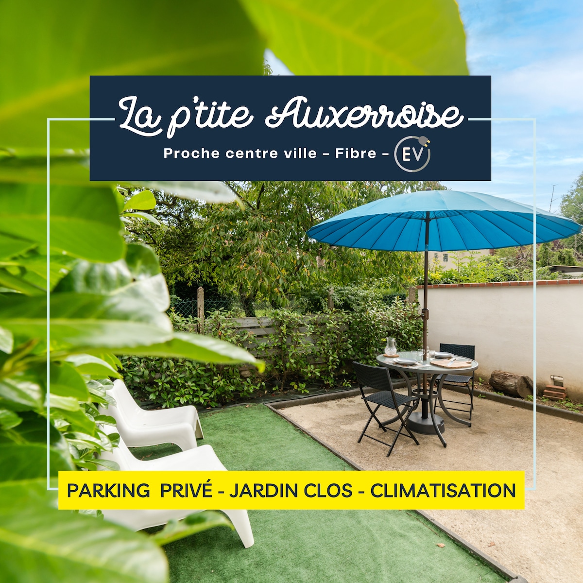 A private garden area is shown featuring a shaded patio with a blue umbrella. Two white chairs are positioned on a green surface, providing a relaxing space for outdoor enjoyment. Surrounding greenery adds to the tranquil setting of La p'tite Auxerroise.