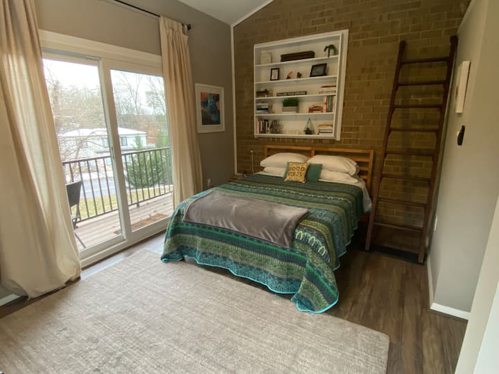 „Sunrise Suite“ დიდი საწოლით, რომელიც აღჭურვილია აივნითა და ლოფტით. Ოთახში დილის სინათლეა. 