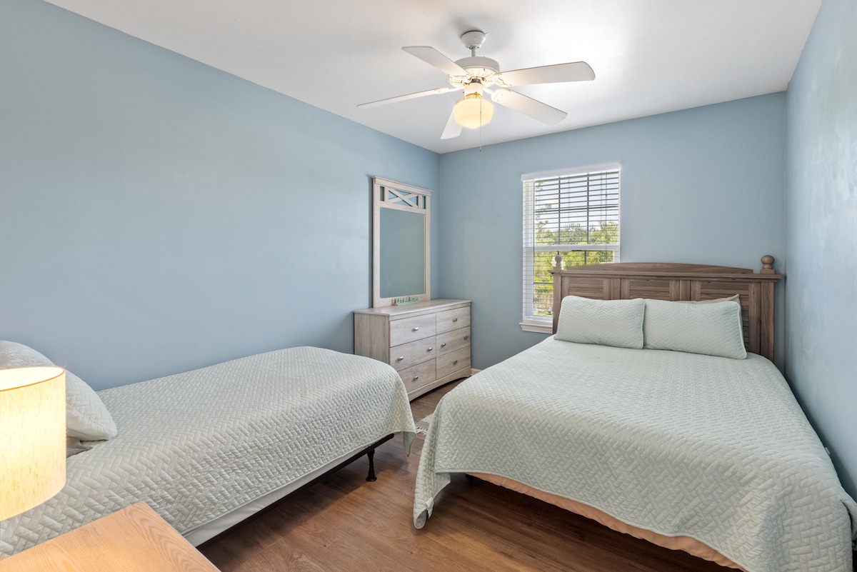 Middelste kamer - queensize bed/twee eenpersoonsbedden en dressoirs en USB-lamp. Let op: de middelste kamer wordt dit jaar (2026) geschilderd in de populairste grijze kleur van Sherman Williams: Agreeable Grey. 