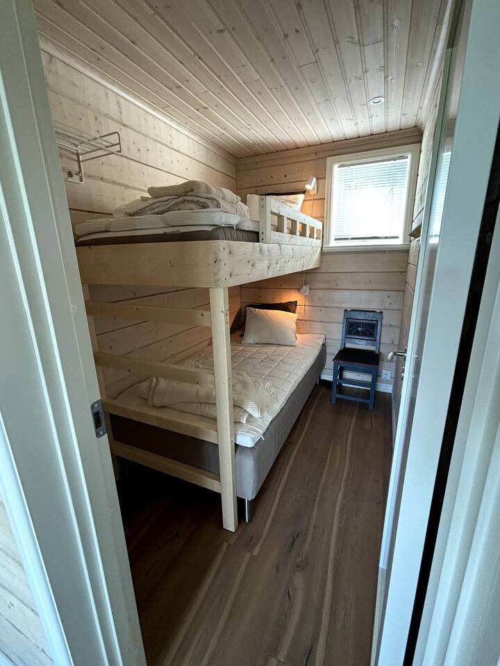 חדר שינה קטן עם מיטת יחיד בגודל 105 ס"מ ומיטת לופט בגודל 90 ס"מ.