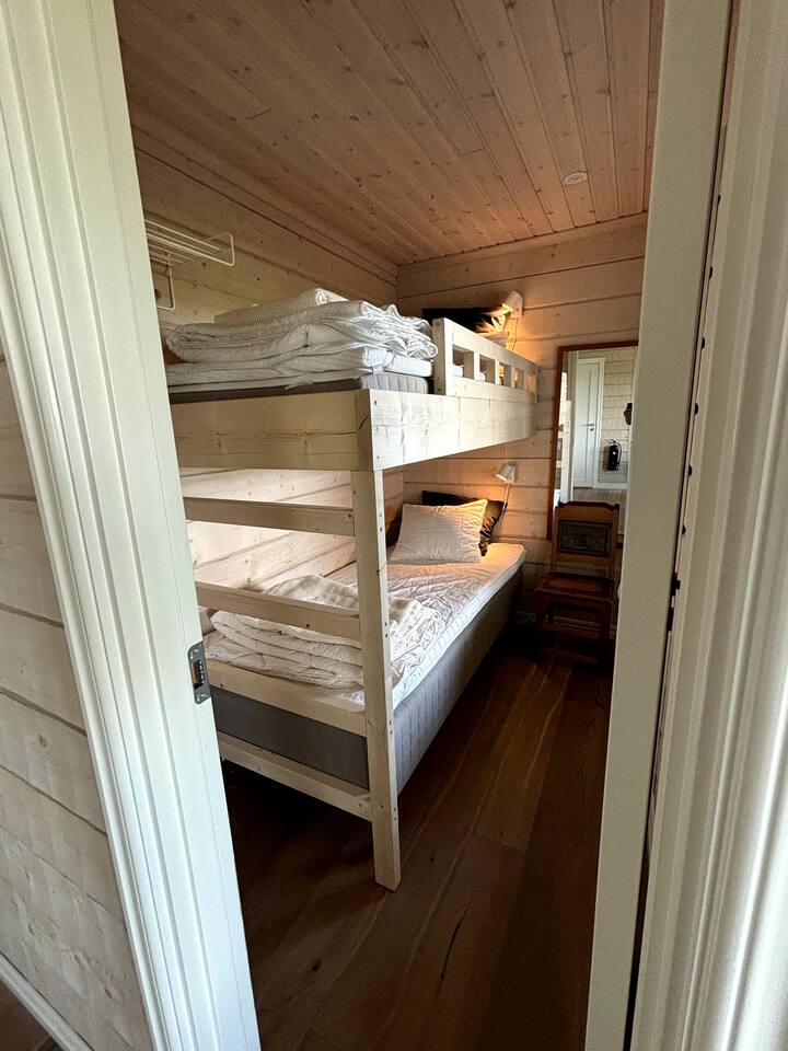 חדר שינה קטן עם מיטת יחיד נפרדת בגודל 90 ס"מ ומיטת לופט בגודל 90 ס"מ.