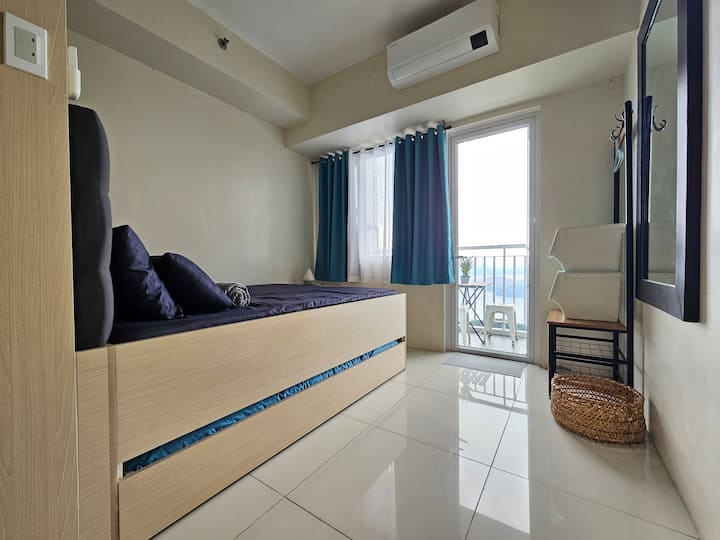 Seamless connection between sleeping area and balcony with a view of Taal Lake.