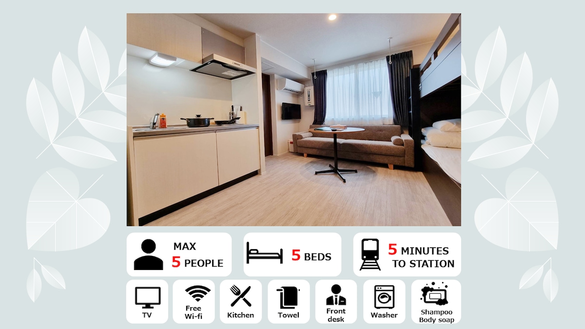 The space features a well-equipped kitchen with a stovetop and microwave. A dining table is positioned near a window, providing natural light. A cozy sofa is placed alongside the wall, creating a comfortable seating area, and a king bed is located at the far end of the room.