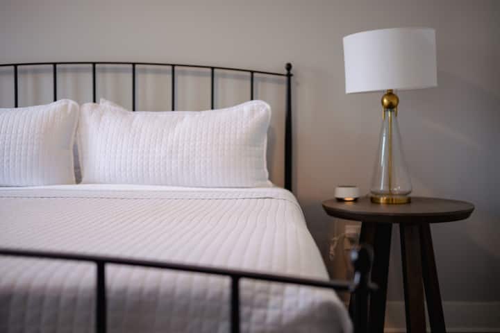 Sleep in comfort in the stylish bedroom, with cozy bedding and ample natural light.