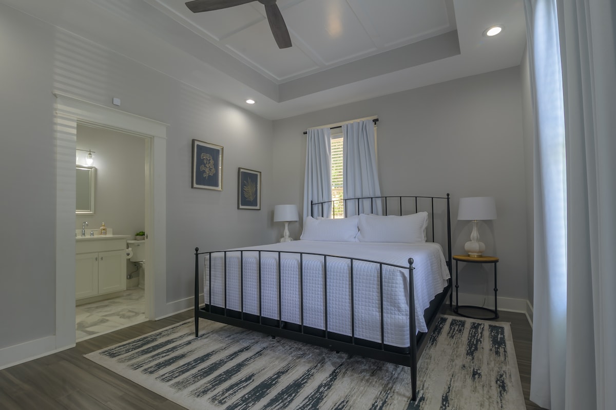 Main bedroom with private bathroom, walk in closet, and smart TV