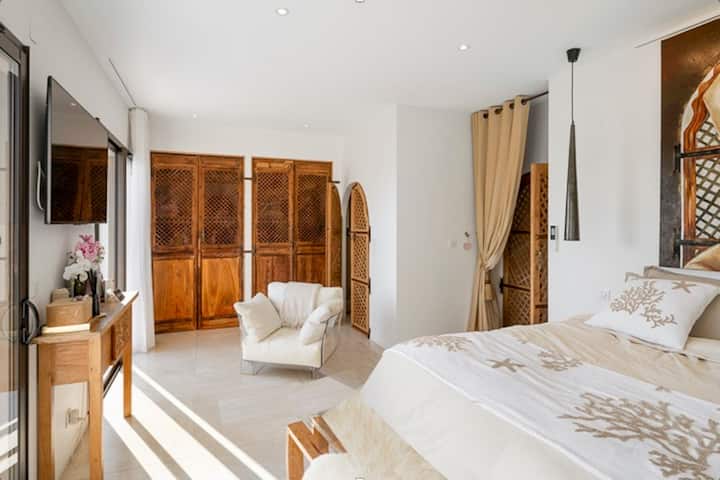 Spacious and bright room, elegantly decorated in light and natural tones. Large double bed, reading chair, solid wood storage and television. A comfortable and refined space, ideal for resting in peace.

