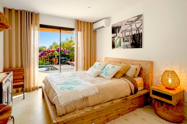 Bright room in a bohemian style, with direct access to a flowery terrace and a private pool. Comfortable bed, air conditioning, natural decor and soothing atmosphere. Perfect for a quiet stay in a warm and well-located villa.
