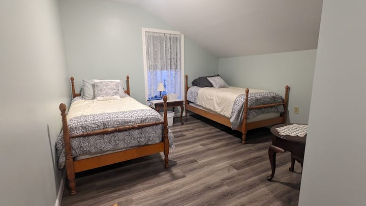 Chumba kimoja chenye vitanda viwili pacha.   Chumba hicho kina kioo cha urefu kamili, kabati, kabati na kiti cha kusomea chenye mwanga.