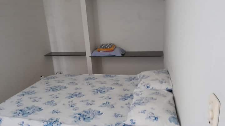 ห้องนอนเตียงคู่พร้อมผ้าปูที่นอน พัดลมติดเพดาน และเคเบิลทีวี