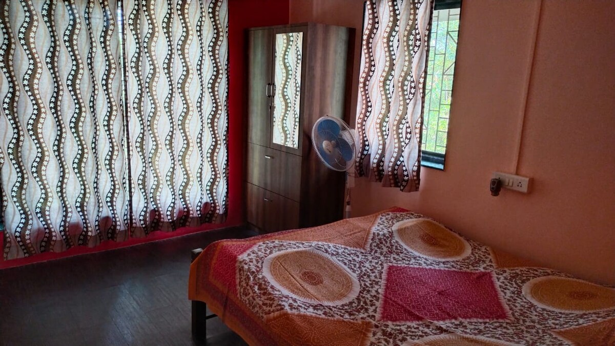 Dhomë gjumi dopio me ventilator për piedestale, gardërobë dhe dollap pranë krevatit.