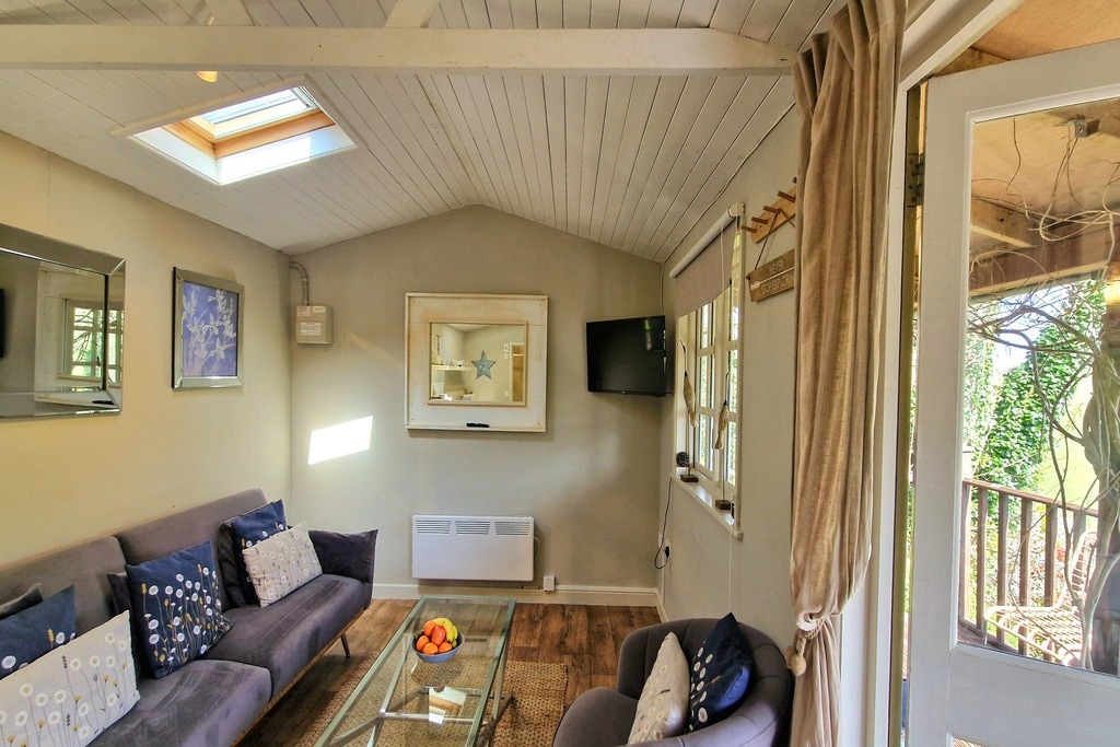 Sala de estar luminosa y cómoda con sofá cama opcional y TV inteligente