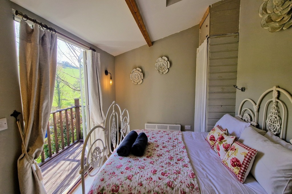 Acogedor dormitorio con cama doble y acceso directo al balcón con tarima