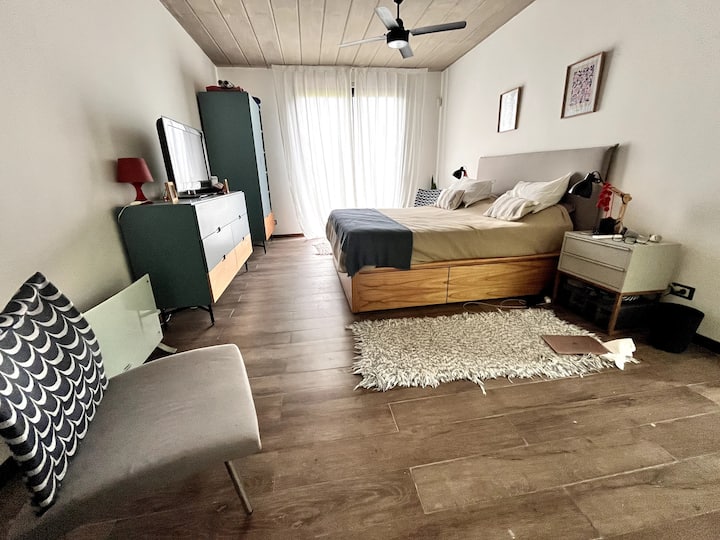 Hoofdslaapkamer met queensize bed, plafondventilator en airco 