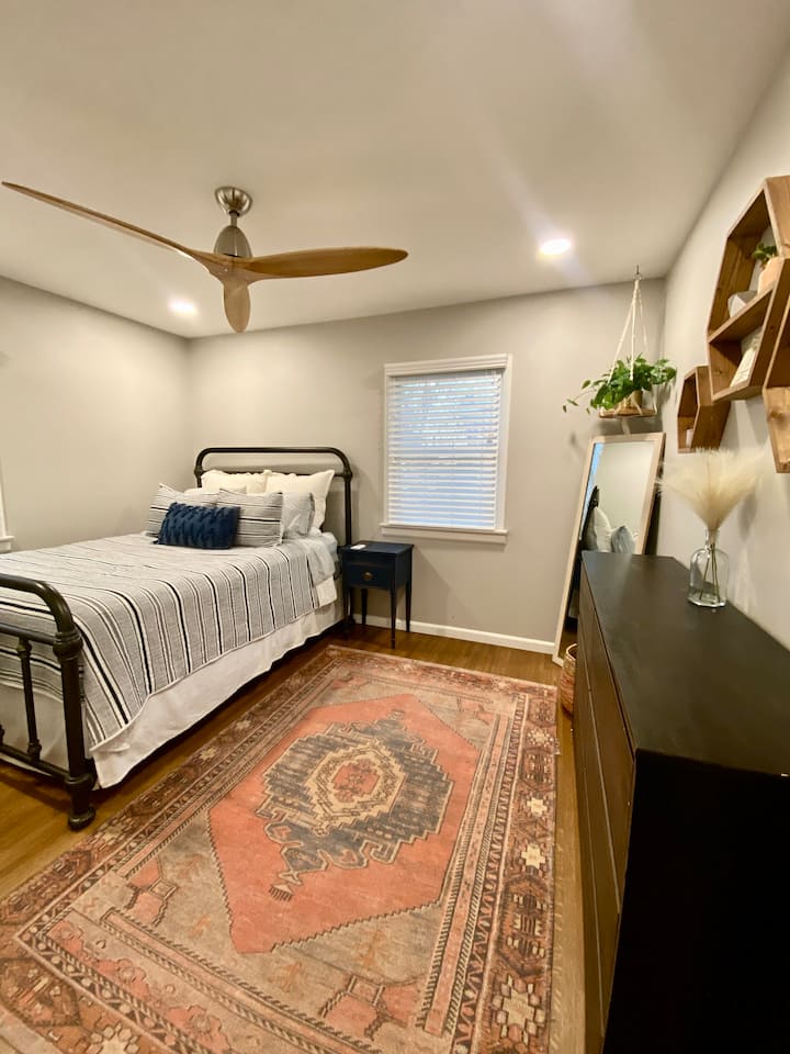 ห้องพักสไตล์โบโฮพร้อมเตียงขนาดควีนไซส์และตู้เสื้อผ้าขนาดกำลังดี ห้องพักกว้างขวางนี้มีไฟแบบฝังและพัดลมเพดานที่ทันสมัย 