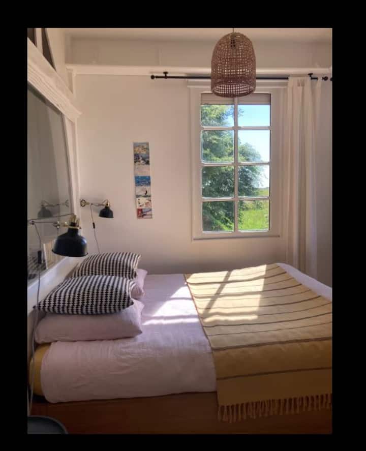 Cama de 160 con vistas al jardín y al faro, persianas eléctricas, estores opacos y cortinas 