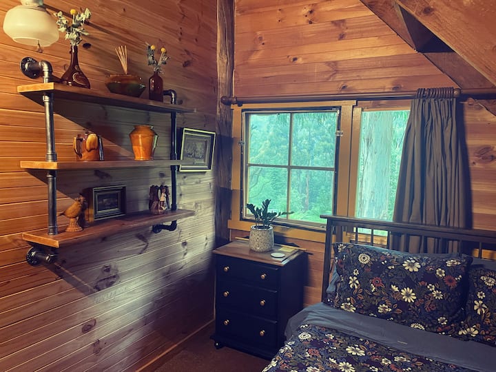 La tranquilla camera da letto matrimoniale offre una splendida vista sugli alberi della gomma e sulle felci rigogliose del giardino circostante.