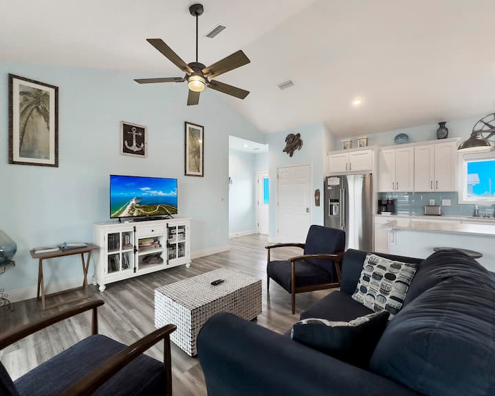 Living room with cable and Internet-connected TV looking towards the foyer and entrance to house and the kitchen off to the side