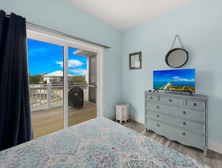 Guest bedroom with queen size bed and Internet-connected TV looking towards access to porch