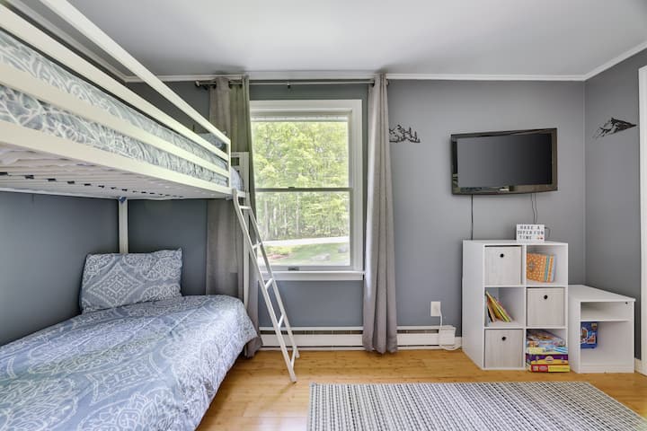 Dieses Schlafzimmer verfügt über zwei Etagenbetten und einen Smart-TV. 