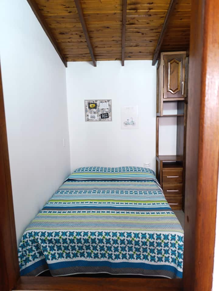 Letto matrimoniale della seconda camera da letto, con tre cassetti in noce per riporre gli oggetti personali.