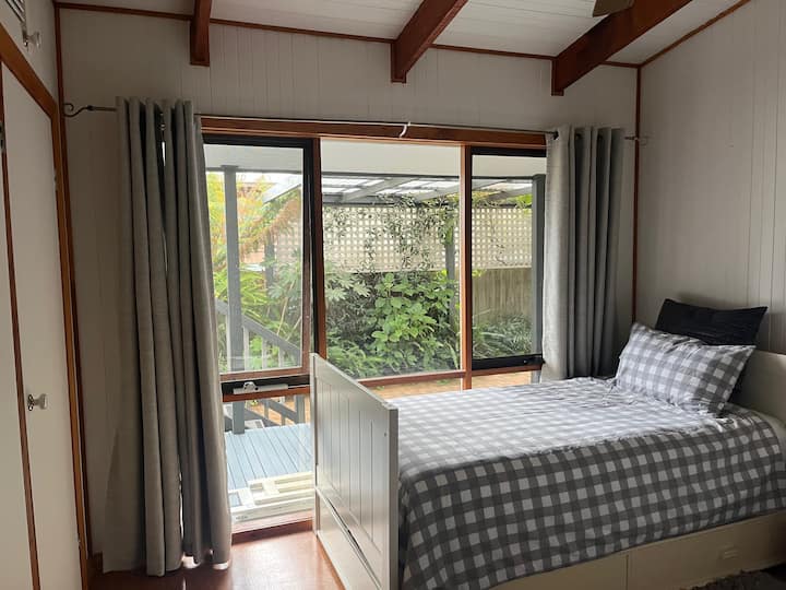 ห้องนอนที่ 2 มีเตียงคิงไซส์ 2 เตียง  มีโต๊ะข้างเตียง โคมไฟ พัดลมเพดาน และตู้เสื้อผ้า  มองเห็นระเบียงด้านข้างและสวน