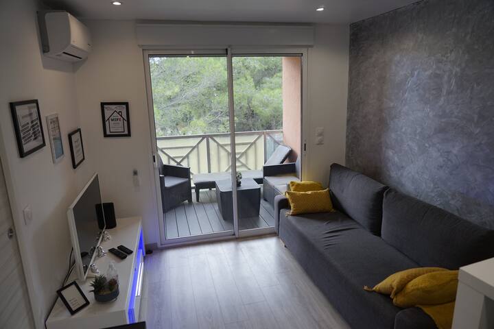 Salón moderno de estilo zen, equipado con un sofá cama de dos plazas, ideal para una estancia en la Costa Azul.  Wi-Fi incluido para su comodidad y necesidades de conexión. 