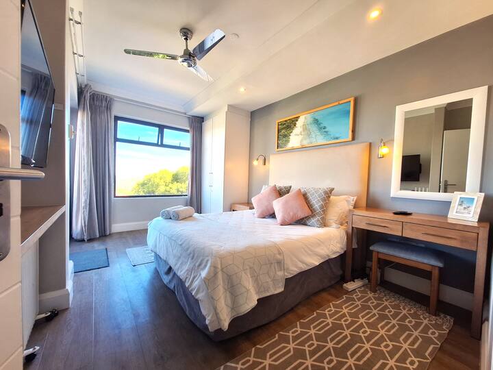 The expansive en-suite main bedroom includes a television and access to the first-floor balcony, ensuring a peaceful night's sleep.