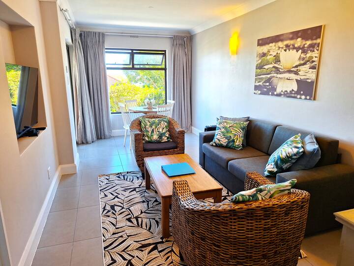 Lounge with sofa couch, coffee table, tv (DSTV and Netflix) and dining area.