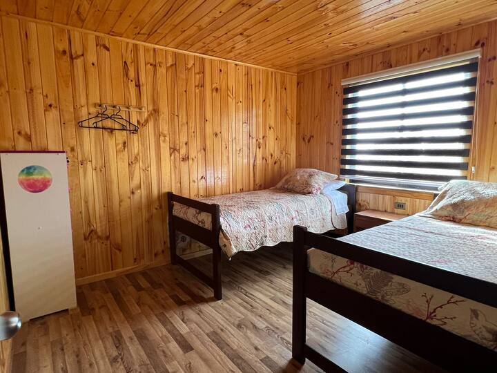 Удобна соба со два двокреветни кревета, цветни прекривки за кревети и ѕидови од природно дрво кои зрачат со топлина. Компактната гардероба и куките на ѕидот нудат практичност. Прозорецот со ролетни овозможува да влезе природна светлина. ️