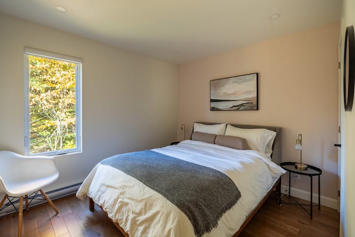 Bedroom with queen bed. Each of the four bedrooms is equipped with a queen bed, chair and storage space for clothes.