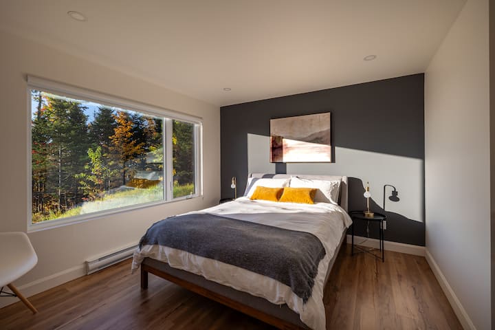 Bedroom with queen bed. Each of the four bedrooms is equipped with a queen bed, chair and storage space for clothes.